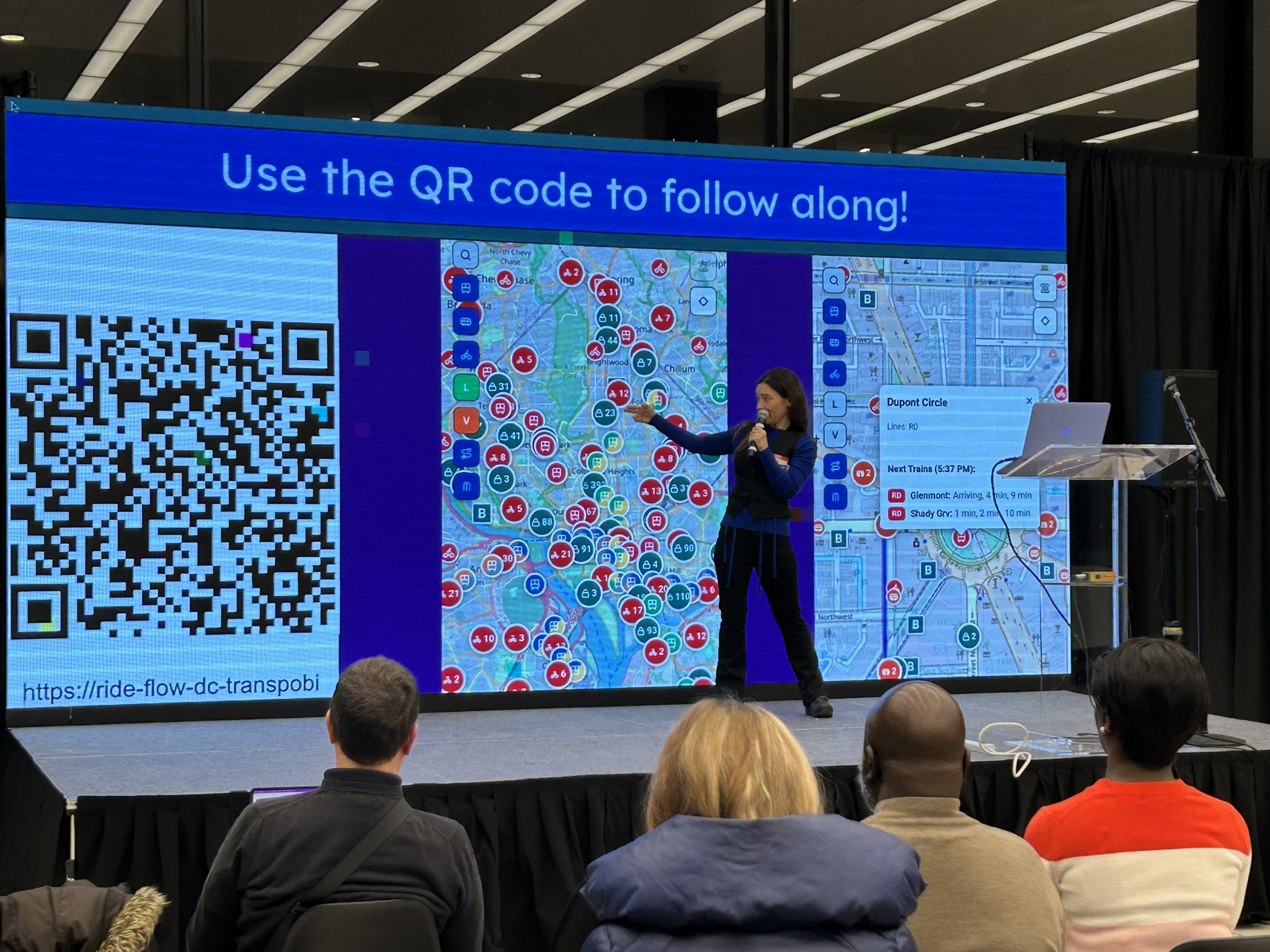 EChO presenting RideFlow DC on a large stage screen showing the live map and a QR code